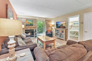 Ein Wohnzimmer mit Kamin, Sofa, Couchtisch und Fernseher.