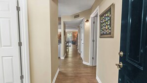 A hallway with wooden flooring, beige walls, and white doors. - two bedroom condo sleeps 7 persons (Gatlinburg)