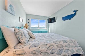 Un dormitorio con cama, ventana, televisión y decoración en la pared.