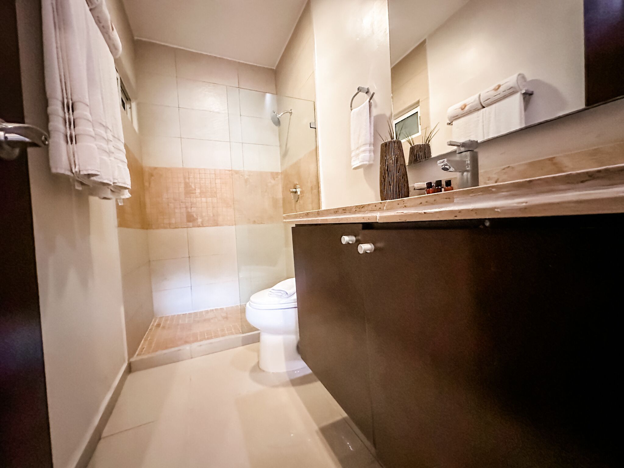 A bathroom with a toilet, a shower, and a sink.