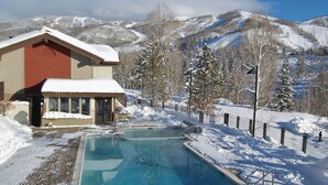 Zona de piscina con vista a montañas nevadas.