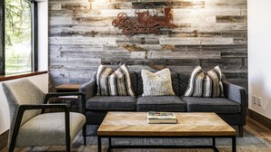 A modern living room with a stone wall, a sofa set, a coffee table, and a chair. - Walk to Main Street/Town Lift I Hot Tub I Sauna I Managed by Park City Lodging (PARK CITY)