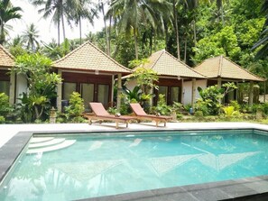 A pool area with lounge chairs and a clear view of a tropical garden. - Crystal Bay Pool View Bungalow (Penida Island)