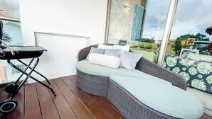 A balcony with a wicker sofa, a grill, and a view of the city. - Trendy 2 Bedrooms + Near Mamita's Beach + Seps from 5th av- Playa del Carmen (Playa Del Carmen)