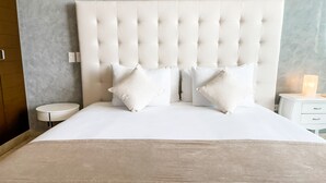 A bed with a tufted headboard, two bedside tables, and a bedside lamp. - Trendy 2 Bedrooms + Near Mamita's Beach + Seps from 5th av- Playa del Carmen (Playa Del Carmen)