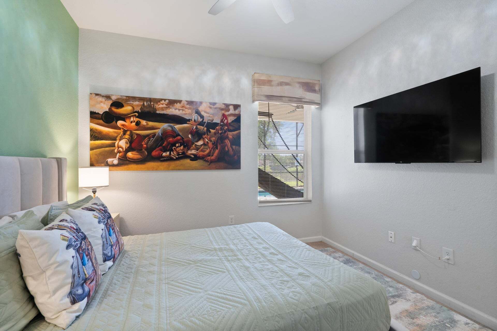 Une chambre à coucher avec un lit, un tableau, une télévision et une fenêtre.