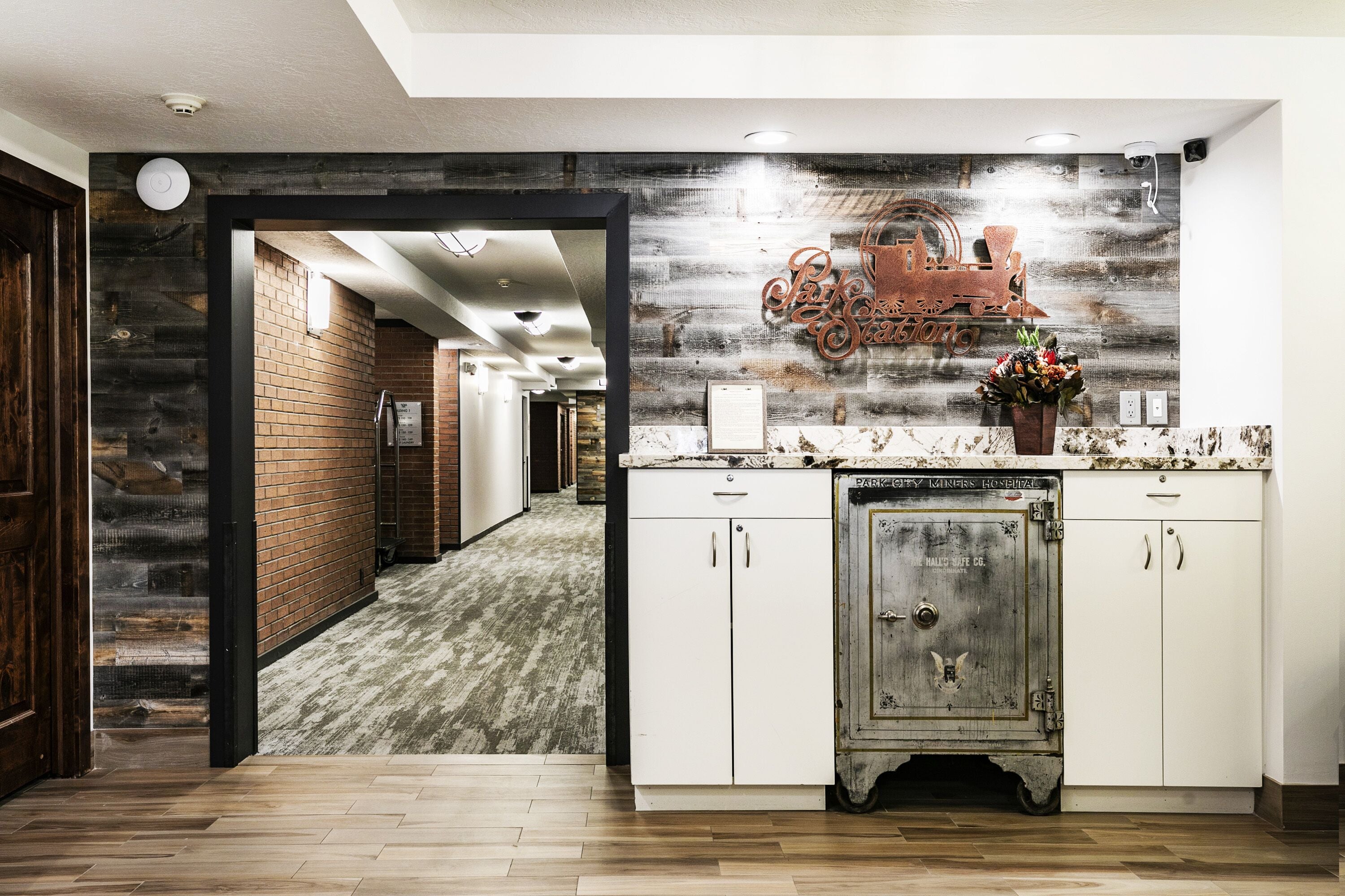 A kitchen with a rustic design, featuring a wooden wall, a vintage refrigerator, and a decorative sign.