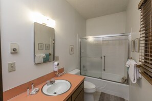 A bathroom with a sink, mirror, and a glass-enclosed shower. - Stand Alone, Pet Friendly Home - Great for Families! (Whitefish)