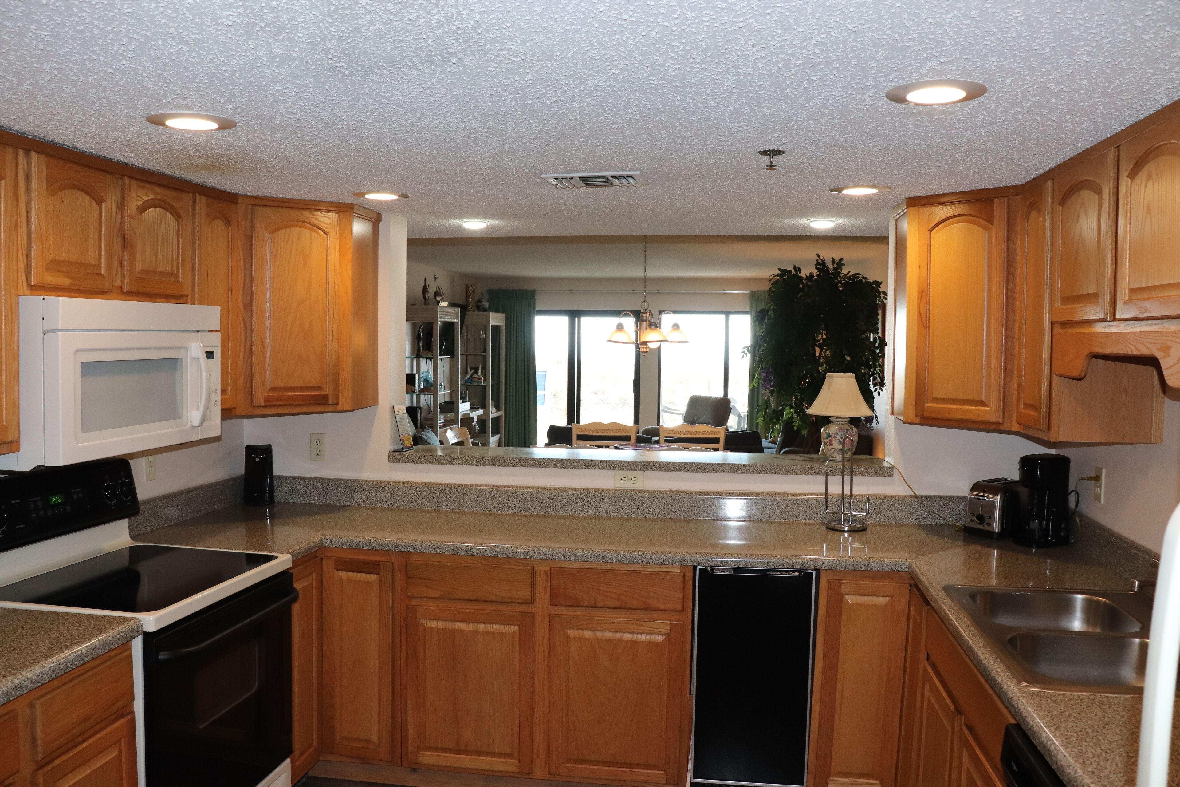 A modern kitchen with wooden cabinets, a microwave, stove, and dishwasher.
