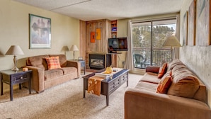 A living room with a sofa, a coffee table, a TV, and a fireplace. - Trails End 509, Breckenridge (Breckenridge)