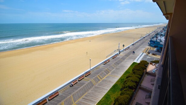 A beach view from a balcony with a wooden walkway, a sandy beach, and a clear sky. - Ocean Hideaway 607-Oceanfront 18th St, Free WiFi, Elev, W/D, AC (Ocean City)