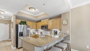 Una cocina moderna con una isla central, electrodomésticos de acero inoxidable y armarios de madera.