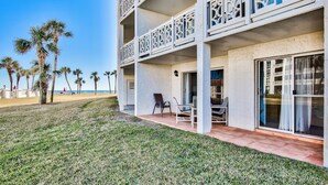 A multi-story hotel with balconies, a grassy lawn, and palm trees. - El Matador 413 by Alicia Hollis Rentals FREE TICKETS! $300/Day (Fort Walton Beach)