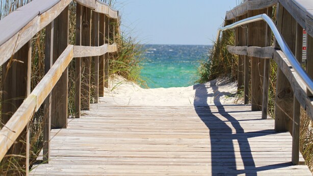 A wooden boardwalk leading to a beach with clear turquoise water. - El Matador 413 by Alicia Hollis Rentals FREE TICKETS! $300/Day (Fort Walton Beach)
