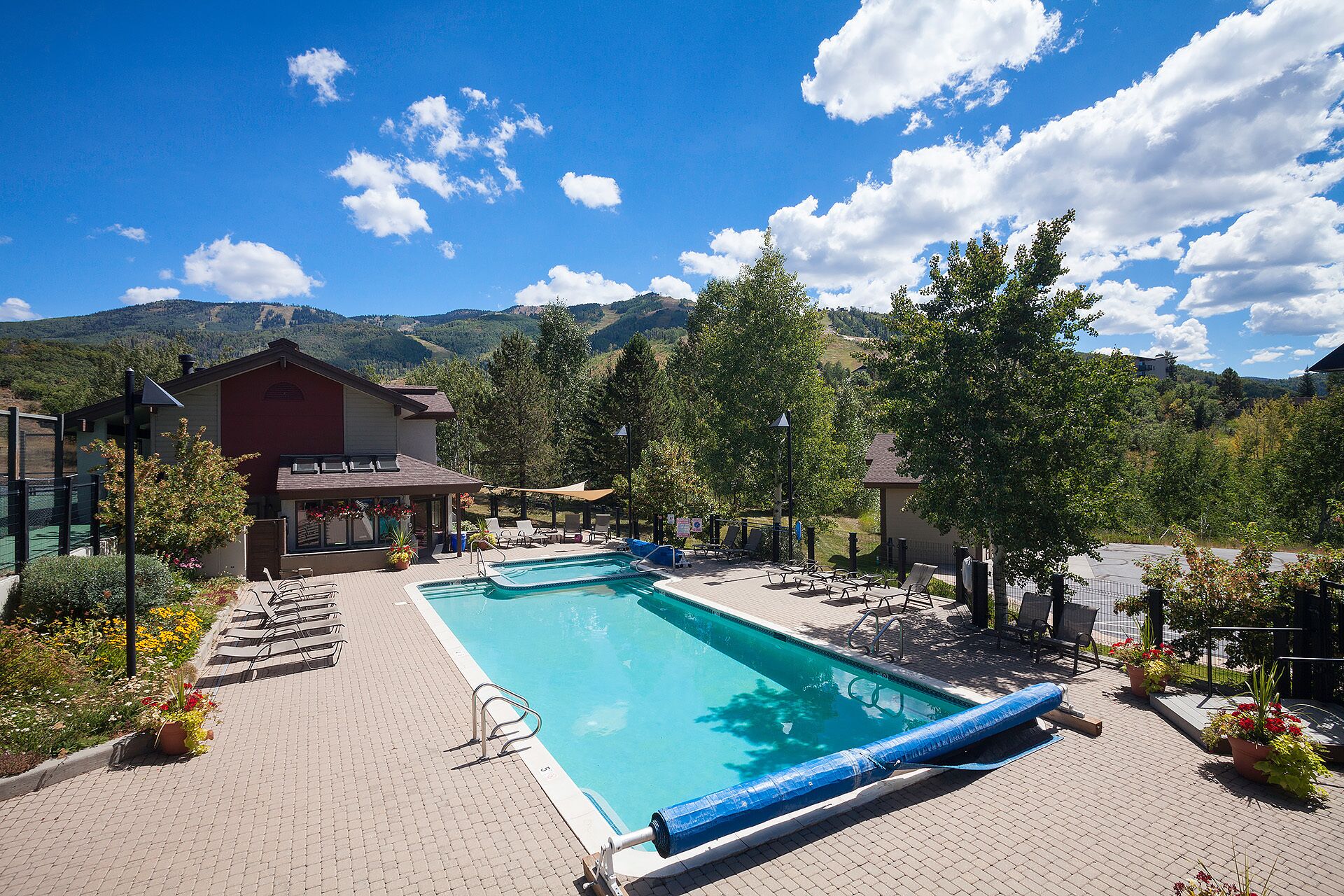 Une piscine avec des chaises longues et une vue sur les montagnes.