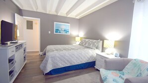 A bedroom with a bed, bedside tables, a dresser, a television, and a painting on the wall. - Jada 4H-Oceanside 77th St, Free WiFi, Pool, Elev, W/D, AC (Ocean City)