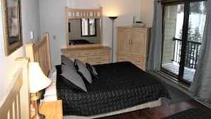Un dormitorio con cama, cómoda, espejo y ventana.