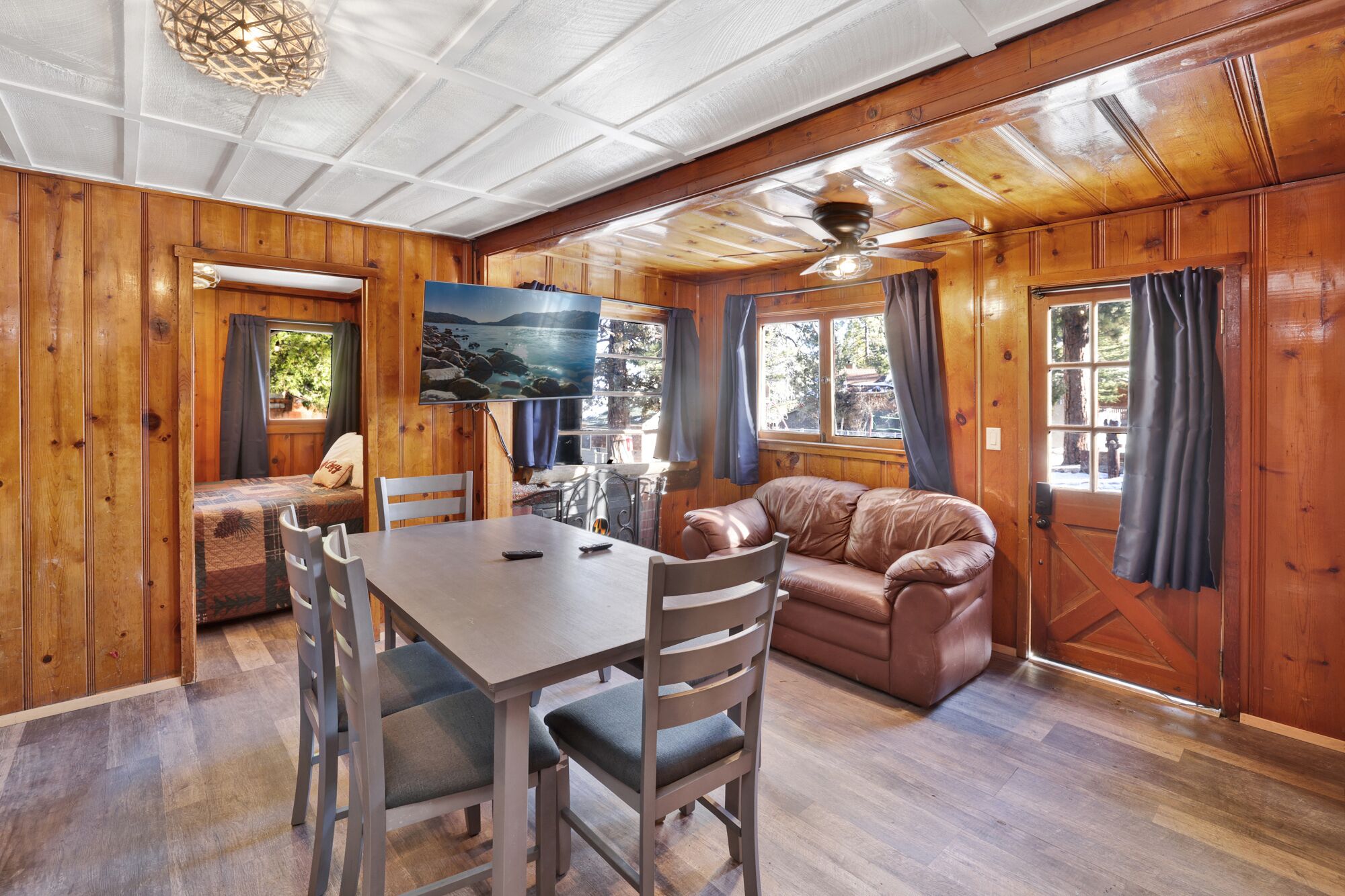 Cozy cabin living room with a stone fireplace, comfy seating, and rustic wood details—perfect for relaxing evenings, movie nights, and unforgettable mountain getaways.