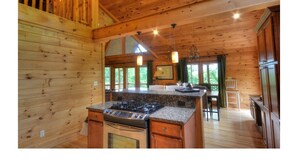 Una cocina amplia con paredes de madera y una estufa grande tipo isla.