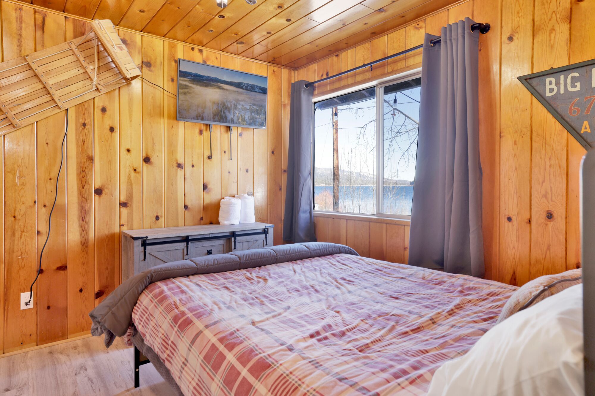 A queen size bed with a TV to enjoy a movie night.