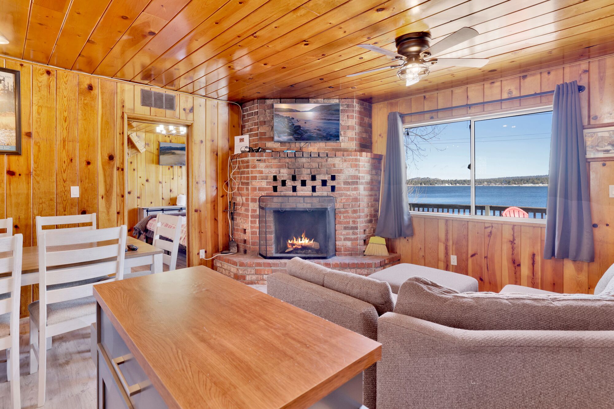 Cozy cabin living room with a stone fireplace, comfy seating, and rustic wood details—perfect for relaxing evenings, movie nights, and unforgettable mountain getaways.