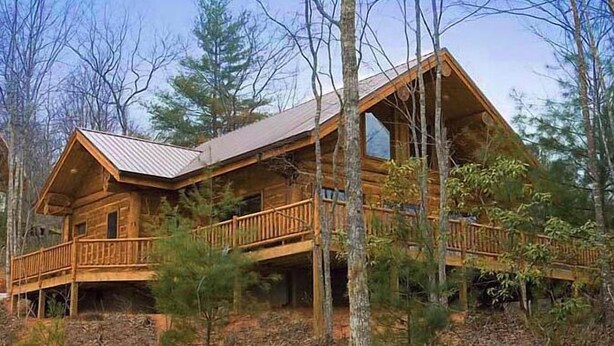 A log cabin with a wooden deck and large windows, surrounded by trees. - Stargazer - Free Train Tix + Modern-Rustic Cabin (Bryson City)