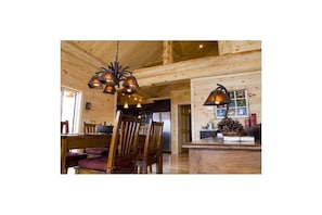 Cozy cabin-style dining area with a wooden table and chairs, perfect for meals and relaxation.