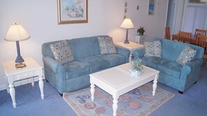 A living room with two blue sofas, a white coffee table, and two lamps on white side tables. - High Point South 3F-Oceanfront 112th St,Free WiFi,Pool,Elev,W/D,AC (Ocean City)