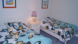 A bedroom with two beds, a nightstand, and two framed pictures on the wall. - High Point South 3F-Oceanfront 112th St,Free WiFi,Pool,Elev,W/D,AC (Ocean City)