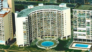 A high-rise hotel with a circular pool surrounded by a walkway, multiple balconies, and a central courtyard. - High Point South 3F-Oceanfront 112th St,Free WiFi,Pool,Elev,W/D,AC (Ocean City)