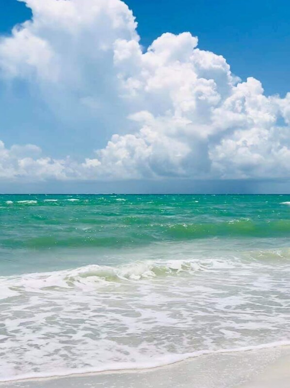 Na praia, guarda-sóis, toalhas de praia