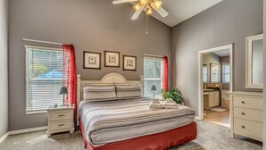 A bedroom with a bed, nightstands, a ceiling fan, and a view into the kitchen. - Enjoy In Pool Dining, Hot Tub & Games Rm. Disney 4 Miles. Pet Friendly (Kissimmee)