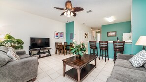 Relax in this stylish living room with a flat-screen TV, comfortable sofas, and a dining area.