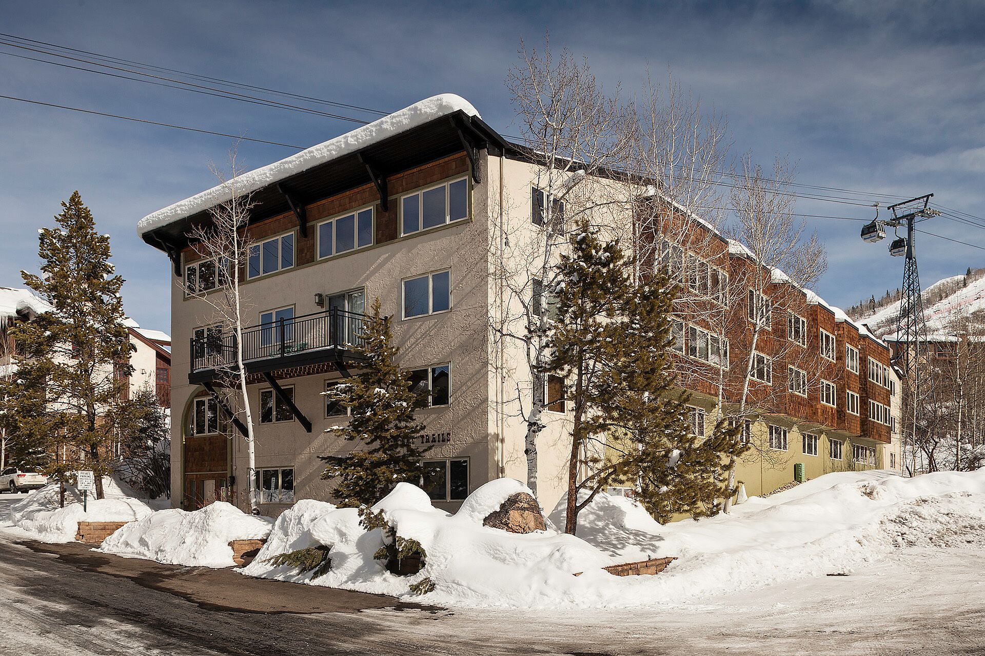 A multi-story building with a snow-covered roof and several balconies.
