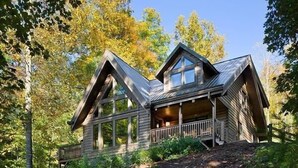 A cabin with a steeply pitched roof, large windows, and a porch. - Romantic Cabin,Views,Pet-Friendly,Trails (Ferguson)