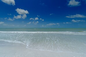 A beach with clear skies and gentle waves. - Steps To The Beach, Sanibel Siesta Unit #304 (Sanibel)