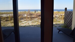 A view from a balcony overlooking a beach with a wooden fence and a sign that reads "KEEP OFF DANGER." - Surf Dweller 103 by Alicia Hollis Rental FREE ADVENTURES $300/Day (Fort Walton Beach)