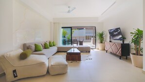 A modern living room with a sectional sofa, a coffee table, and a flat-screen TV.