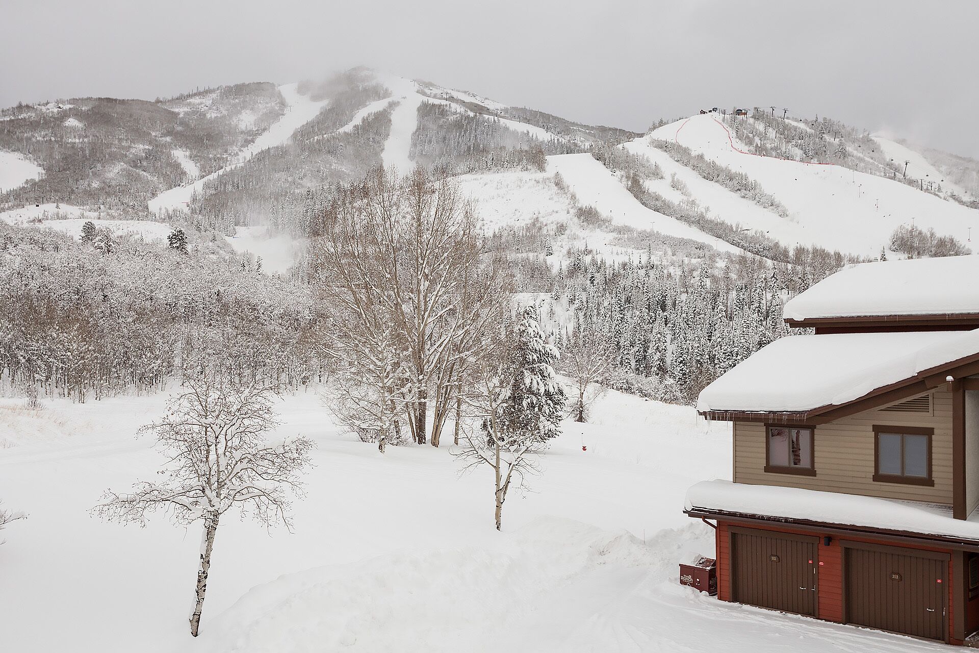 A snow-covered mountain landscape with a cabin.