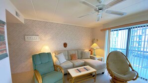 A living room with a ceiling fan, a sofa, a rocking chair, and two lamps. - Ocean Princess 207-Oceanside 134th St, Elev, W/D, AC (Ocean City)