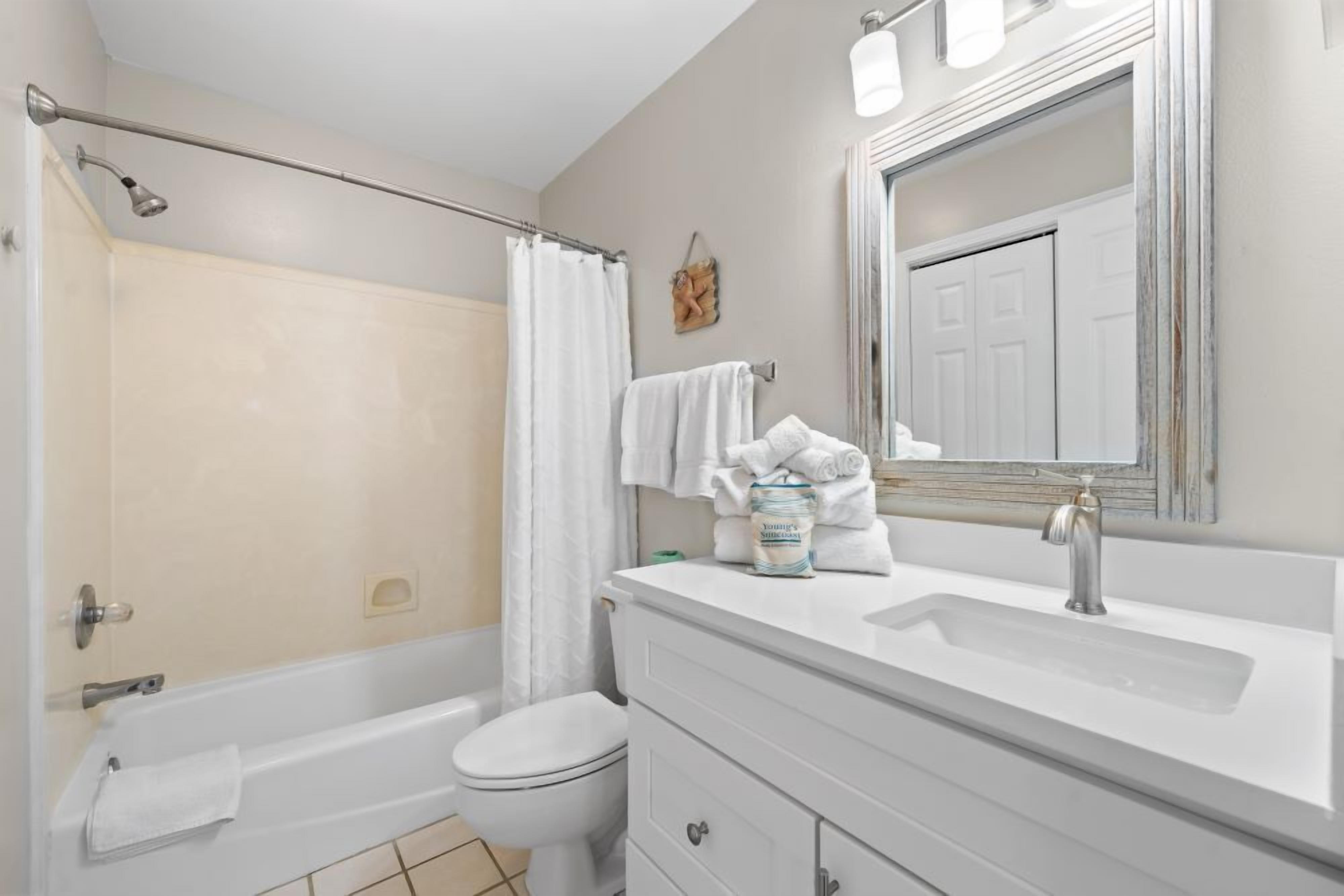 Un baño con bañera, inodoro y lavamanos.