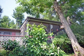 A two-story building with a red door and a white fence in front. - Valley View Cottage - Quiet Cabin w/Firepit near Deep Creek and downtown + free railroad tix (Bryson City)