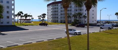 A hotel with multiple floors, a parking lot, and a view of the beach.