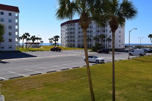 Ein Hotel mit mehreren Etagen, einem Parkplatz und Blick auf den Strand.