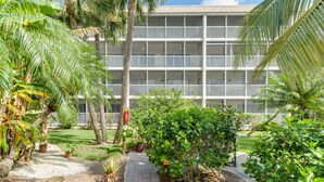 A multi-story hotel with balconies, surrounded by lush greenery and palm trees. - Tropical Getaway (Sanibel)