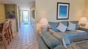 A living room with a sofa, two lamps, and a framed picture on the wall. - Tropical Getaway (Sanibel)