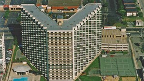 Un immeuble de grande hauteur doté d’une architecture originale, avec une cour intérieure abritant une piscine et des courts de tennis.