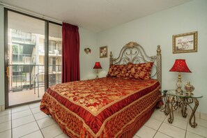 A hotel room with a large bed, a balcony, and a view of the outside.