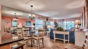 A spacious living area with a dining table, chairs, a sofa, and a TV.