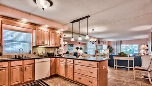 A kitchen with wooden cabinets, a central island, and pendant lighting.